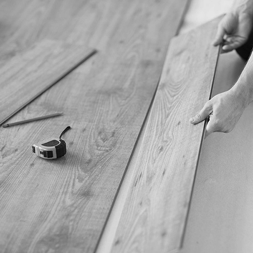 close up of male hands intalling wood flooring